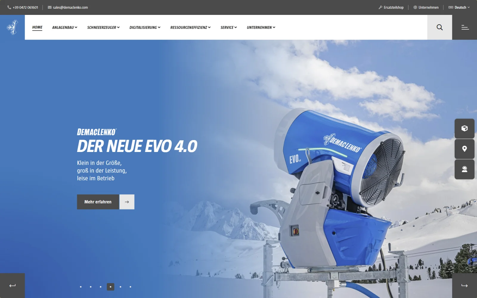 Industrie-Website mit Beschneiungsanlage vor einer Berglandschaft.